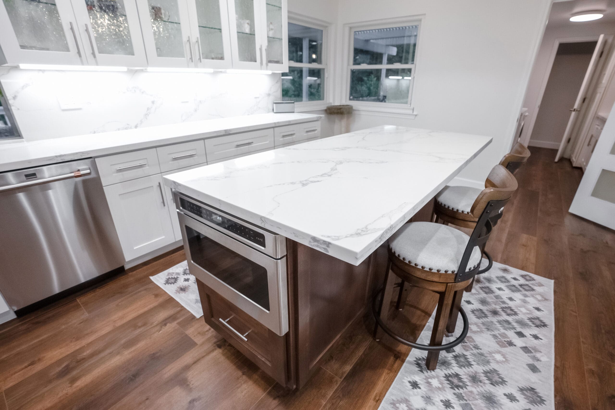 Remodeled kitchen with brown cabinets and white countertops